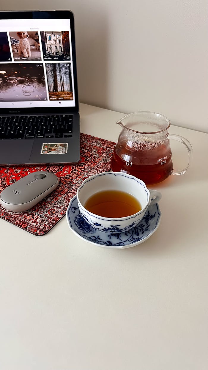 A serene home office setup with tea, laptop, and elegant decor, perfect for productivity.